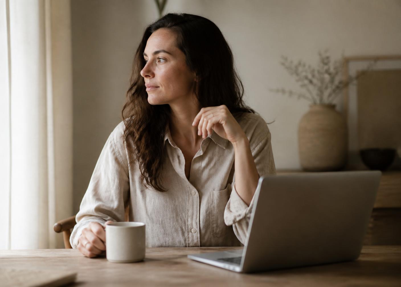 A mother working at her kitchen table with a laptop